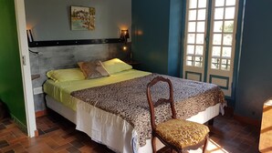 A bedroom with a bed, a chair, a nightstand, a lamp, and a window. - GRAPI Farm with a swim spa for 4 adults and 4 children (CALVI)