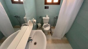 Un baño con bañera, inodoro y cortina de ducha.