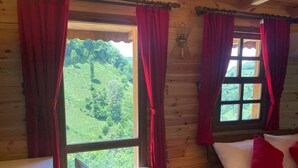 A cabin room with two beds, a wooden wall, and a view of greenery outside. - Derya Dağ Evi (Çamlıhemşin)