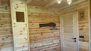 A wooden interior with a bed, a door, and a wall-mounted coat rack. - Derya Dağ Evi (Çamlıhemşin)