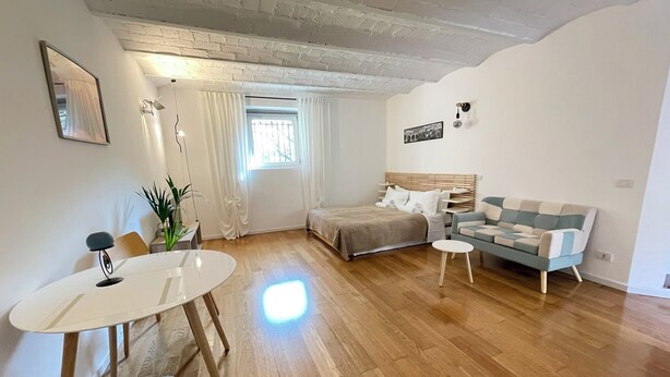 Ein Zimmer mit einem Bett, einem Schlafsofa, einem Esstisch und einem kleinen Tisch.