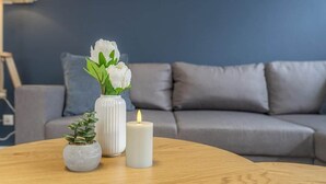 A round wooden table with a white vase and a lit candle. - Bright & Cozy Apartment with Harbor View in Varel (Varel)