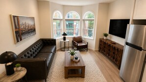 Una sala de estar moderna con un sofá, una mesa de centro y un televisor.