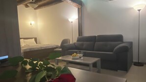 A modern living room with a sofa, a coffee table, and a red rose. - Vouni Calais  (Vouni)