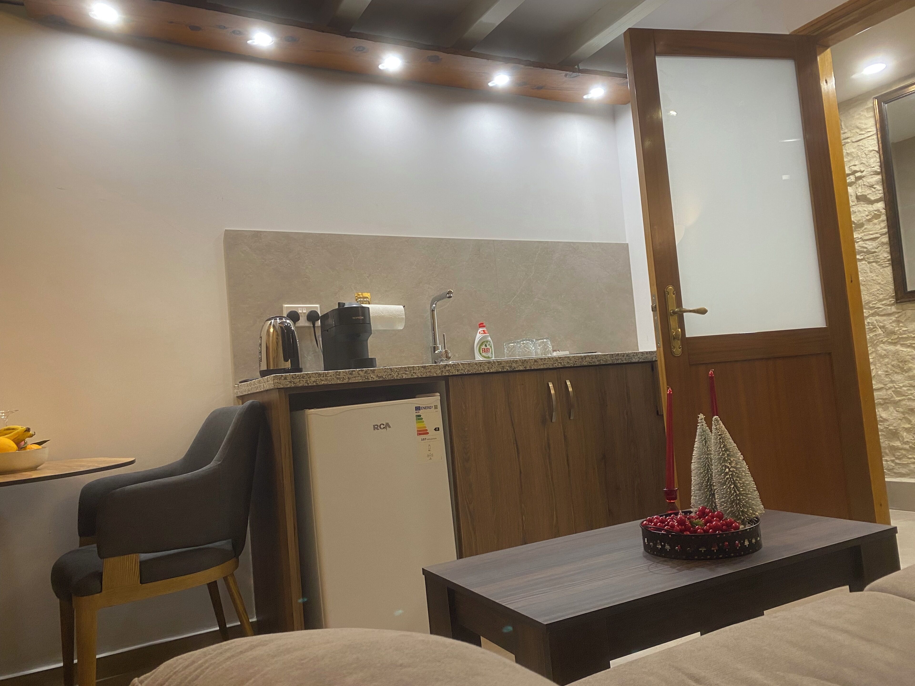 A compact kitchenette with a coffee maker, toaster, and a small refrigerator.