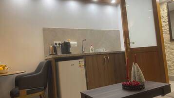 A compact kitchenette with a coffee maker, toaster, and a small refrigerator.