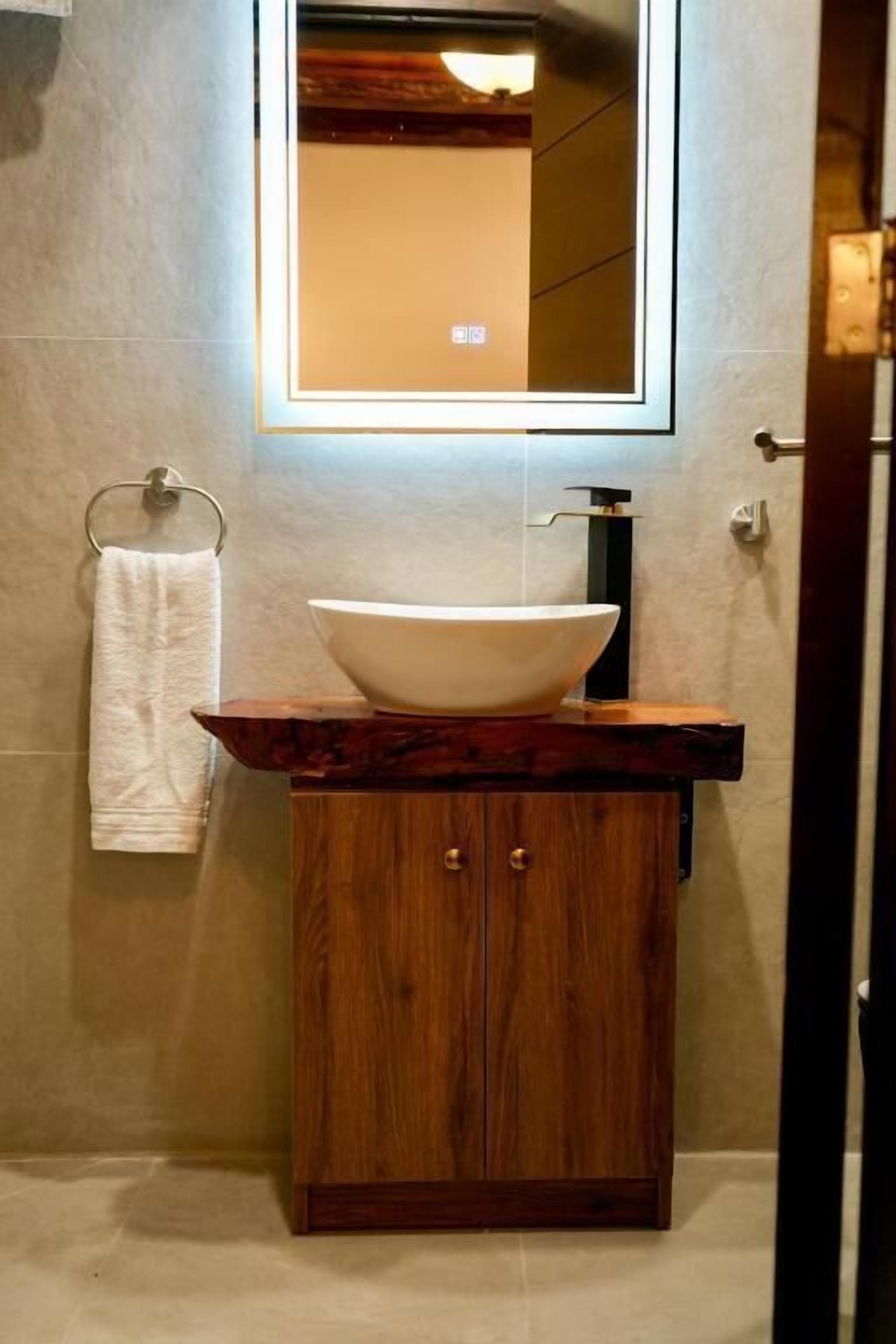 Ein Badezimmer mit einem Holzlagerflächen, einem weißen Waschbecken und einem Handtuchhalter.