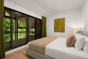 A bedroom with a bed, a window, a painting, and a balcony. - Tremblant Prestige - Verbier 10-203 (Mont-Tremblant)