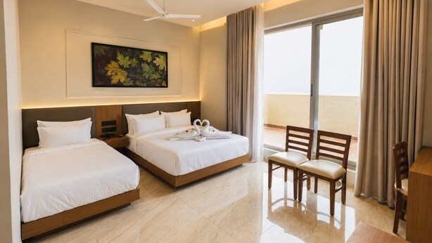 A hotel room with two beds, a ceiling fan, a painting, a view of the sea, and a balcony with a chair. - LUXURIA INN BY CHANDAN (Vanthli)