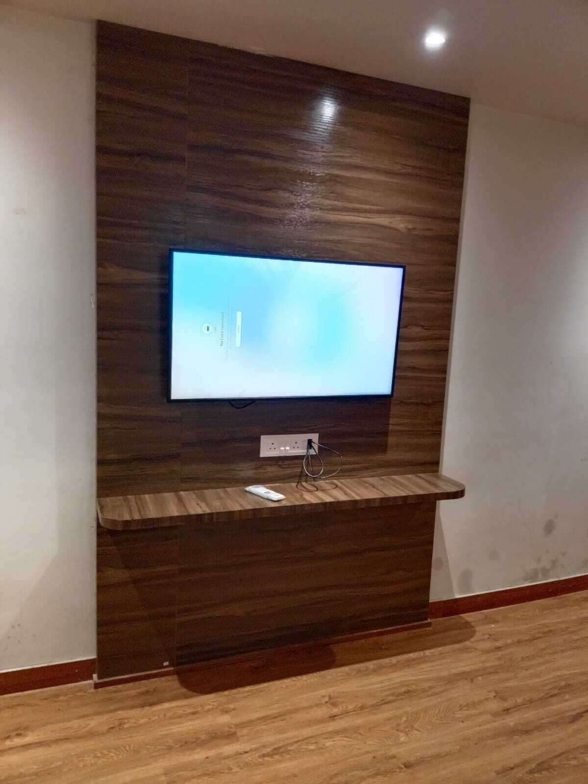 Televisor de pantalla plana fijado en una pared de madera con sistema de organización de cables.