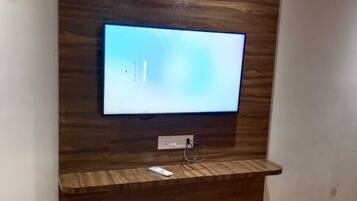 Televisor de pantalla plana fijado en una pared de madera con sistema de organización de cables.