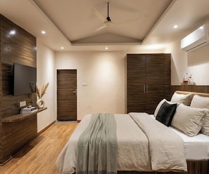 Un dormitorio moderno con cama, armario, televisión y ventilador de techo.