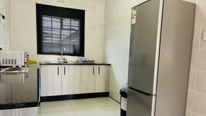 Una cucina con frigorifero in acciaio inossidabile, lavello e pensili in legno.