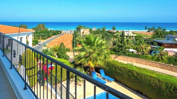 A balcony with a view of a beach, a pool, and surrounding greenery. - Villa Koryfi - Argaka - 3 Bedroom villa minutes walk from the beach (6 guests) (Argaka)