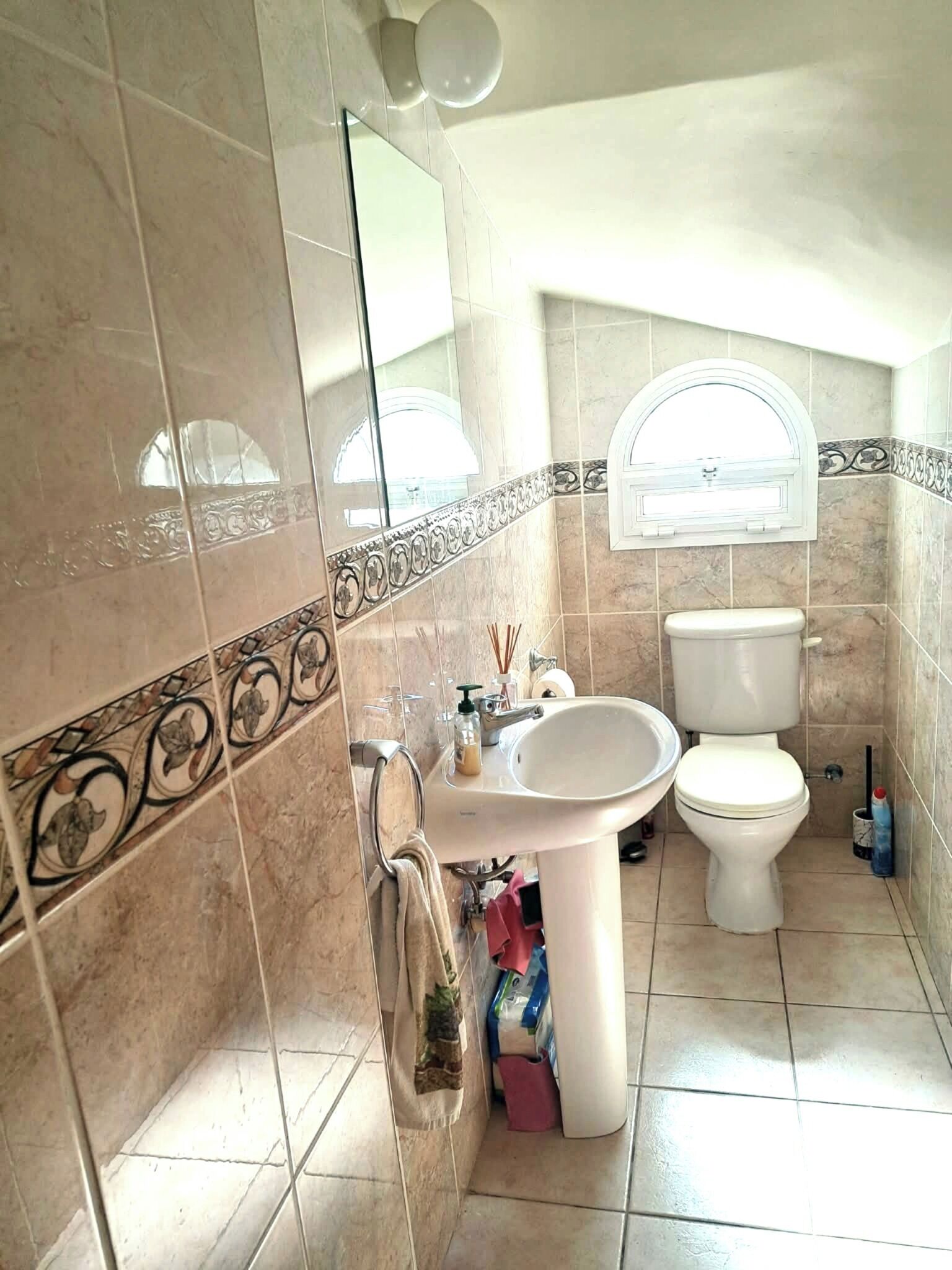 Une salle de bain avec un lavabo, des toilettes et un miroir.