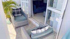 A sunlit patio area with wicker furniture and a potted plant. - No. 17 - The Grand Gaube Retreat – Pool, Turquoise Sea Just Steps Away (Grand Gaube)