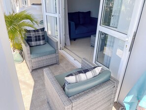 A sunlit patio area with wicker furniture and a potted plant. - No. 17 - The Grand Gaube Retreat – Pool, Turquoise Sea Just Steps Away (Grand Gaube)