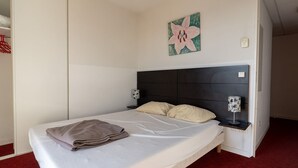A single bed with a dark headboard, two bedside tables with lamps, a wall-mounted artwork, and a red carpeted floor. - Classic Riviera Escape With Pool, Grasse (Grasse)
