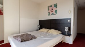 A single bed with a dark headboard, two bedside tables with lamps, a wall-mounted artwork, and a red carpeted floor. - Classic Riviera Escape With Pool, Grasse (Grasse)