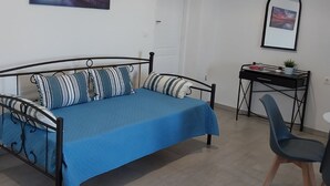 A bedroom with a bed, a desk, a chair, and two wall-mounted lights. - Angira 4 Seaview Escape - Koroni Summer Getaway (Pylos-Nestoras)