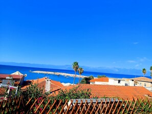 A coastal town with terracotta-roofed buildings, a clear blue sky, and the sea in the background. - Angira 3 Seaview Escape - Koroni Sunny Getaway (Pylos-Nestoras)