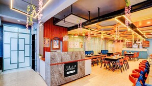 A restaurant interior with a marble counter, seating area, and decorative hanging elements. - Collection O Kotdwar Railway Junction (Kotdwāra)
