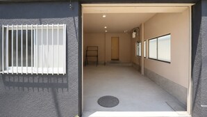 Ein Flur mit Fenster, einer Tür und einer kleinen Stufe, die in einen anderen Raum führt.