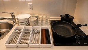 Eine Küche mit einem Herd, Töpfen und Ordnungsgemäßen Kochutensilien auf der Arbeitsfläche.