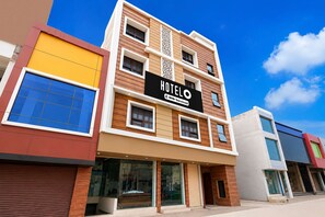 A multi-story hotel with a modern facade, featuring a prominent sign that reads 'HOTEL' and 'YOYO-Serviced.'