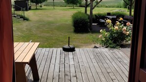 A wooden deck with a table and a barbecue grill.