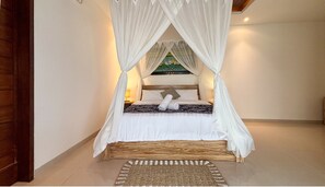 A bed with a canopy, a woven rug, and a painting on the wall. - Padi Mas Villas with Private Pool (Bali)