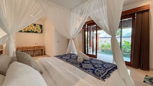 Un dormitorio con cama, almohadas, escritorio y un cuadro.