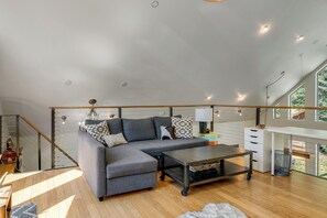 Ein modernes Wohnzimmer mit einer Eckcouch, einem Couchtisch und einer Treppe.