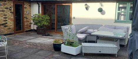 A patio area with outdoor furniture, a brick wall, and a solar panel roof.