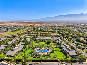 A residential area with a central swimming pool surrounded by houses and greenery. - Remodeled Spacious 3bd Across From Beach I Koa Resort 2H (Kihei)