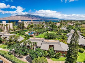 A resort with multiple buildings, a swimming pool, and a view of the ocean and mountains. - Remodeled Spacious 3bd Across From Beach I Koa Resort 2H (Kihei)