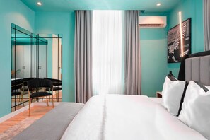 Een moderne hotelkamer met een bed, een spiegel, een bureau en een stoel.