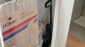 A room with a white door, a shelf with boxes, and a vacuum cleaner. - 2-room apartment with a terrace (Cannes)