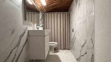 A bathroom with a marble wall, a wooden bench, a toilet, and a sink with a mirror.