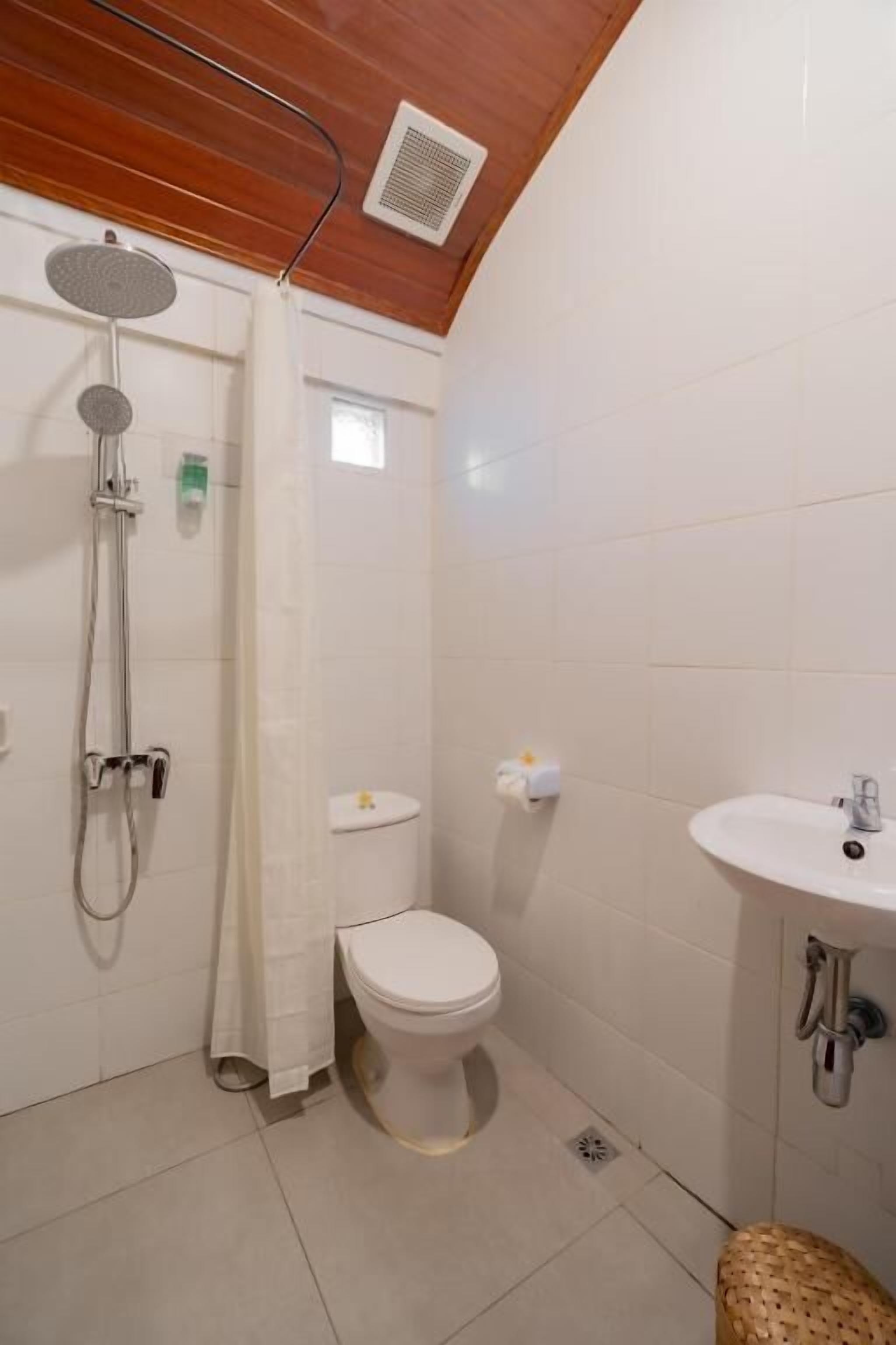 A bathroom with a shower, toilet, and sink.