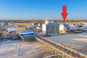 A coastal hotel with a wooden pier, beach view, and modern buildings. - 1st Floor, 2BR Oceanfront Condo, Shared Pool - Sand Dollar 103 (Murrells Inlet)