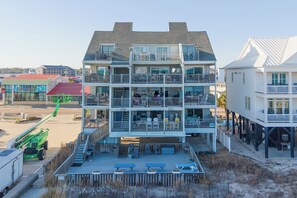 A multi-story hotel with balconies, outdoor seating, and a beach view. - 1st Floor, 2BR Oceanfront Condo, Shared Pool - Sand Dollar 103 (Murrells Inlet)