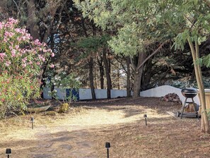 A backyard with a barbecue grill, a white fence, and various trees. - N0 Apt, 3-star rated, GF & 200 m² garden, 150 m from the beach – La Guérinière (La Guérinière)