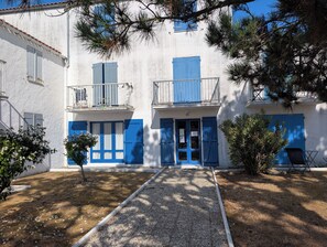 A building with a gravel path leading to a door, surrounded by trees and shrubs. - N0 Apt, 3-star rated, GF & 200 m² garden, 150 m from the beach – La Guérinière (La Guérinière)