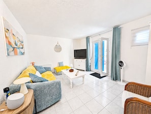 A modern living room with a sofa, coffee table, and a TV. - N0 Apt, 3-star rated, GF & 200 m² garden, 150 m from the beach – La Guérinière (La Guérinière)
