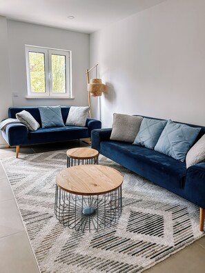 A modern living room with two sofas, a coffee table, and a floor lamp.