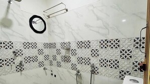Une salle de bain avec une douche, des toilettes et un miroir.