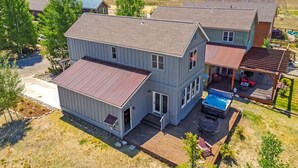 A two-story house with a deck, a hot tub, and a view of the surrounding landscape. - Buckhorn Reserve 3 Bedroom Cabin (Granby)