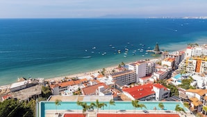 Eine Küstenstadt mit Strand, Gebäuden und freiem Blick auf das Meer.