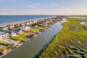 A coastal residential area with houses along a riverbank, a beach, and a marina. - Buoy Haus: Brand-New 2027 Inlet Front Escape w/Pool, Spa & Dock (Murrells Inlet)